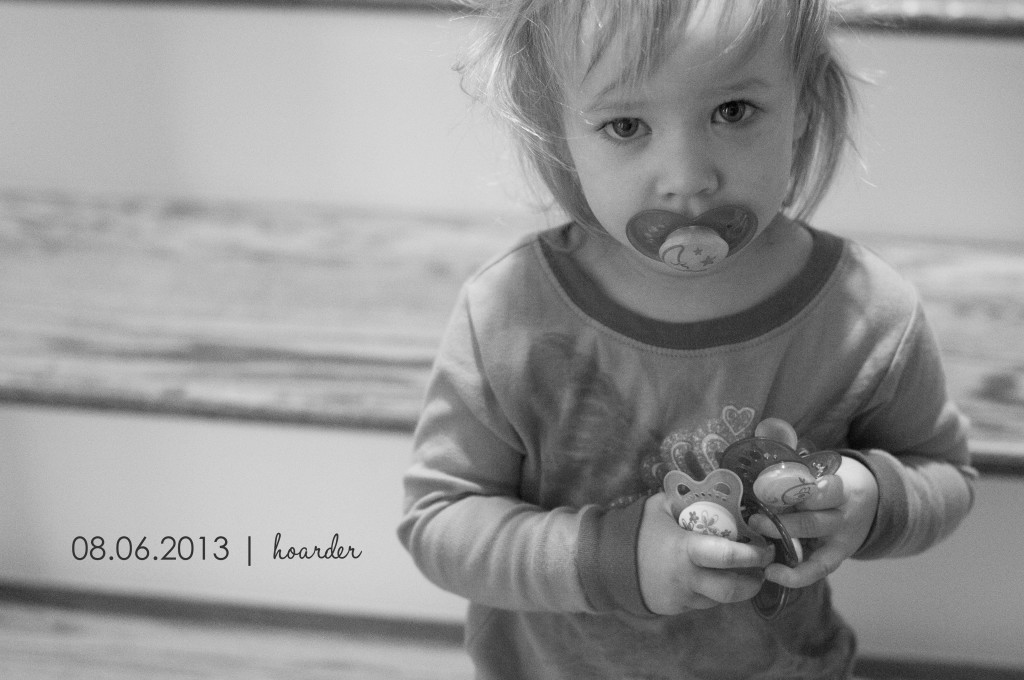 toddler holding pacifiers