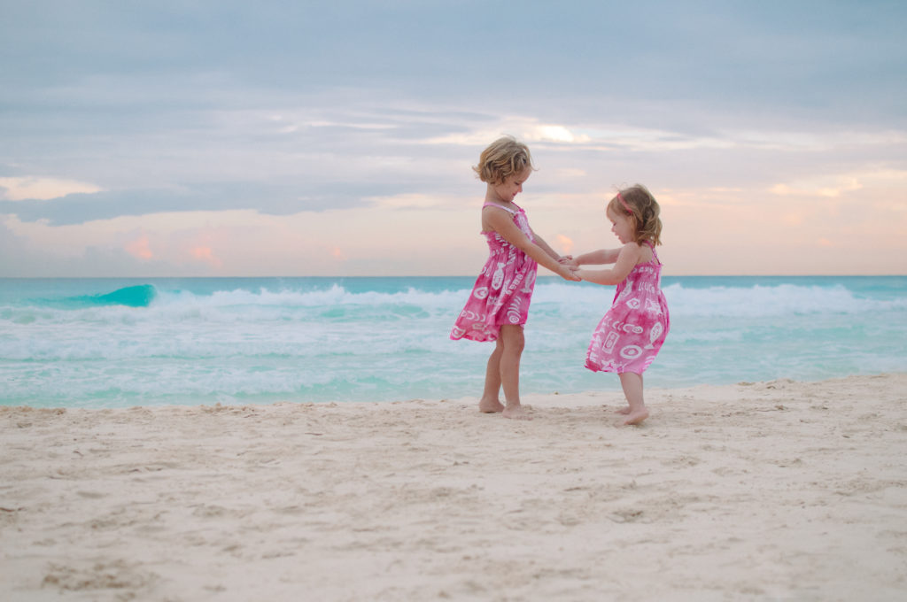 girls pink dresses on beach