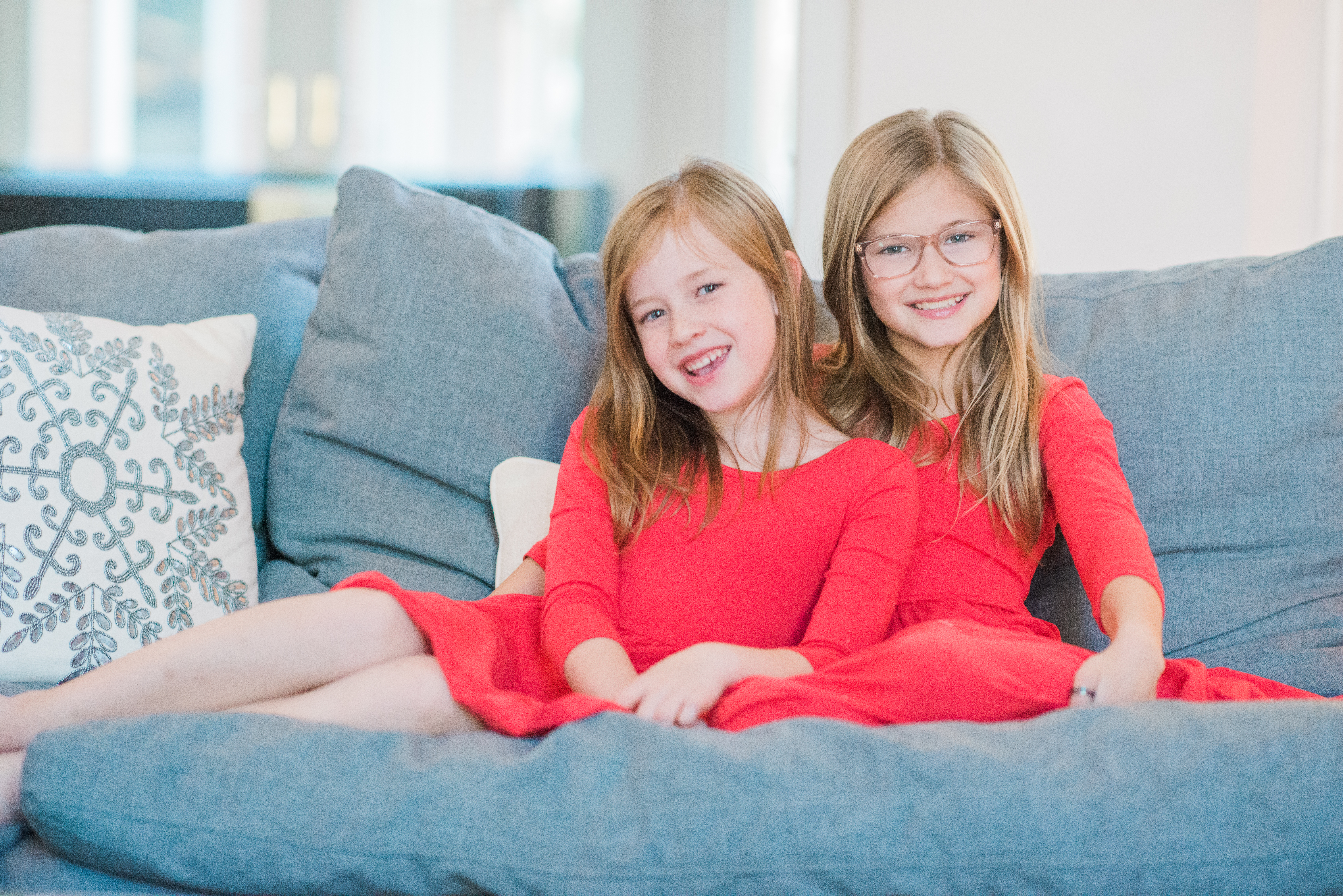 girls smiling on grey sofa
