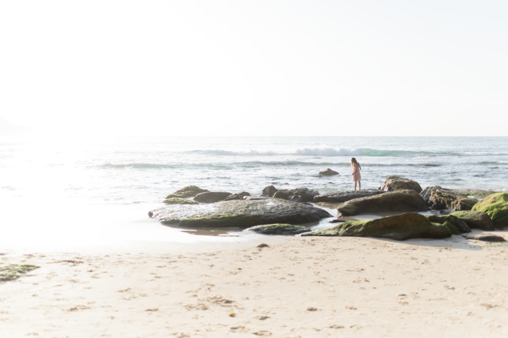 young girl playing on the rocks at sunrise on Bondi Beach
