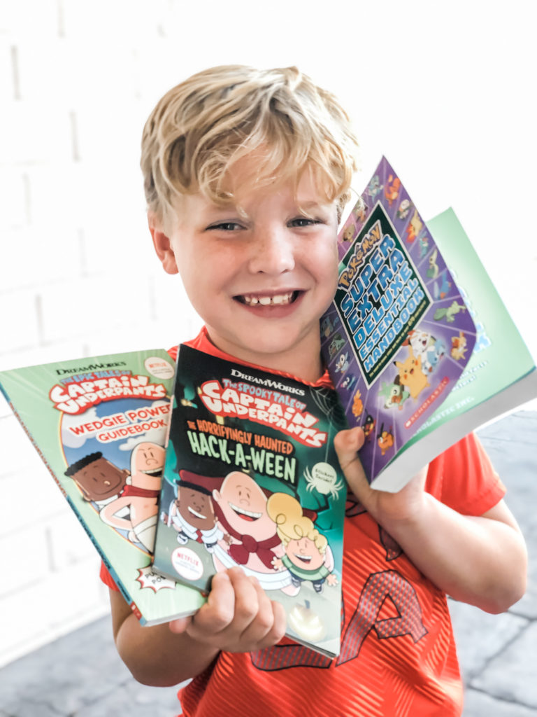 boy with dyslexia holding books he picked out, dyslexia, young reader, captain underpants